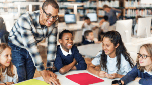 Adult with four students around a table